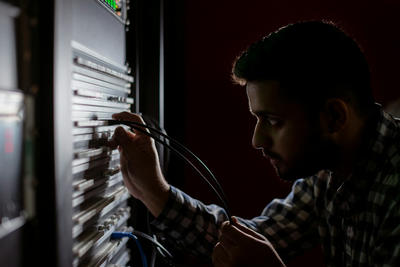 A network engineer tracing a fault at a patch panel, the kind of troubleshooting path triage graphs describe